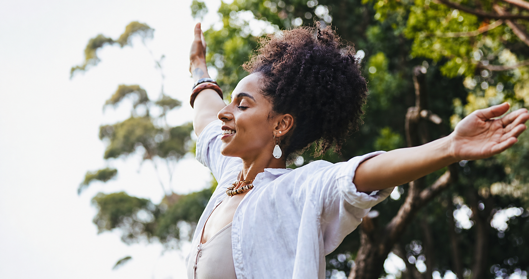 Woman outdoors expressing a sense of freedom and wellness